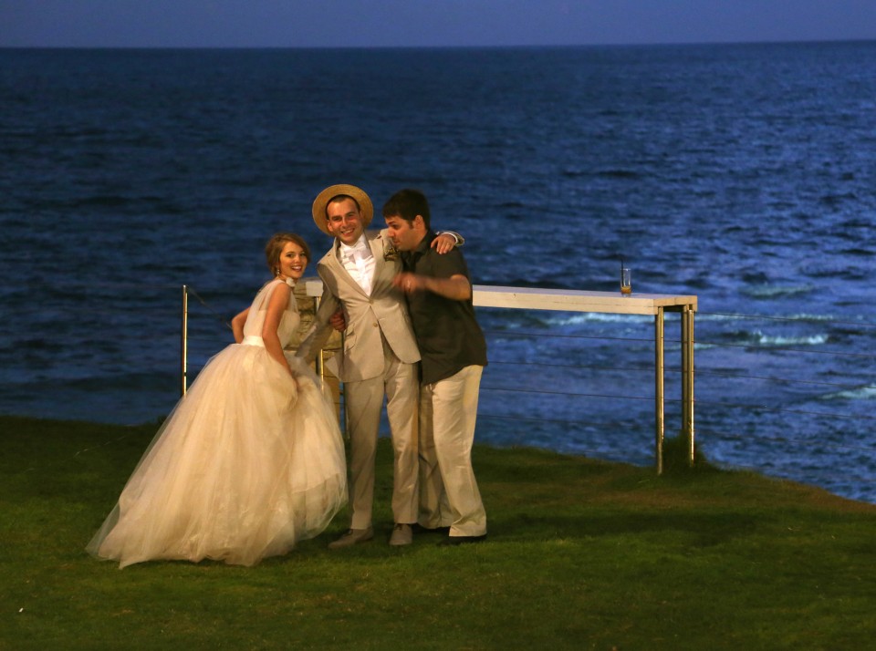 wedding couple with friend by sea