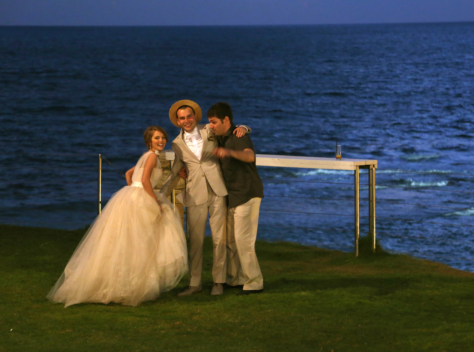 wedding couple with friend by sea