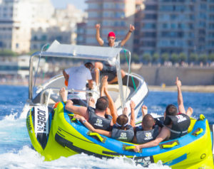 men on inflatable with speed boat