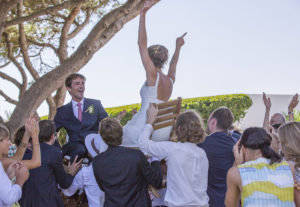 bride and groom on chairs aloft