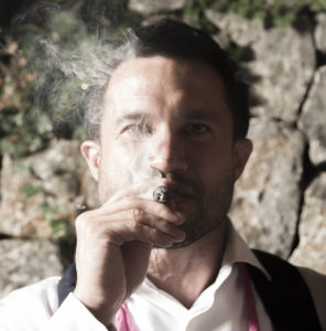 man with cigar poses for photograph