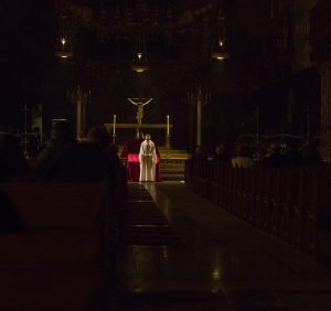 Catholic priest stands at alter