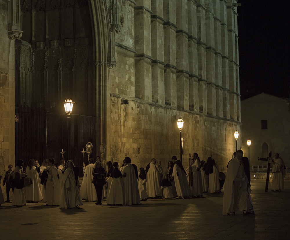 Religious people in costume stand outside Palma Cathedral