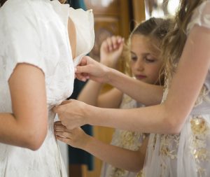 bridesmaids zip the back of the dress